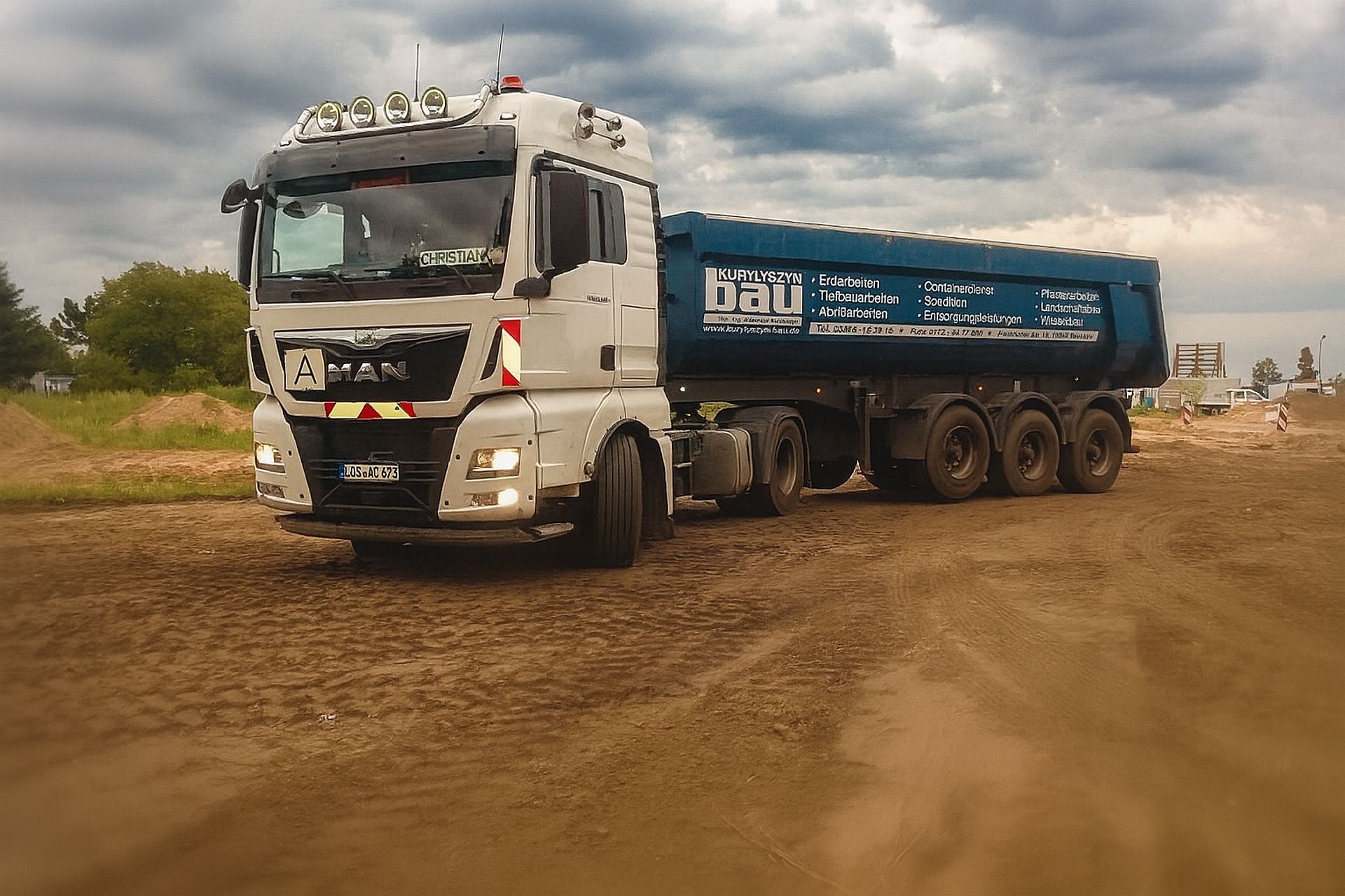 MAN Truck auf sandigem Boden mit Container