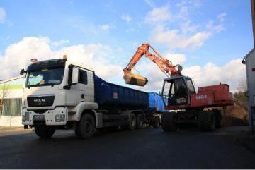 Bagger belädt Container